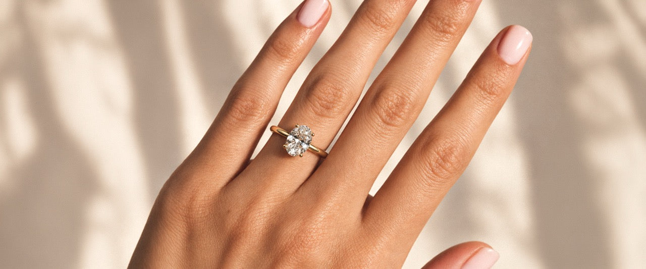 bague de fiançailles en or jaune 18 carats et diamant éthique de taille ovale portée sur une main par la maison de joaillerie Loyal e Paris